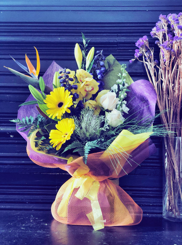 Yellow, Gold Purple Fresh Flowers Arrangement in container