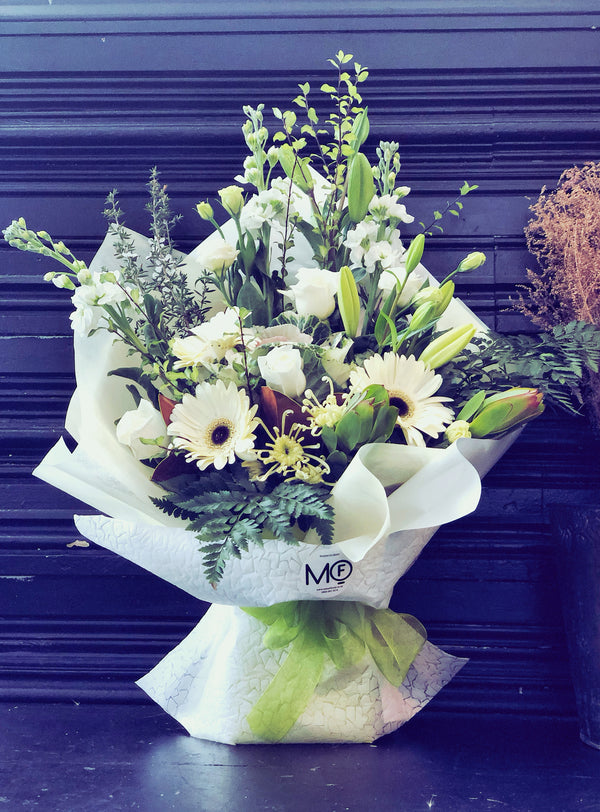 white and green fresh flowers arrangement in container 