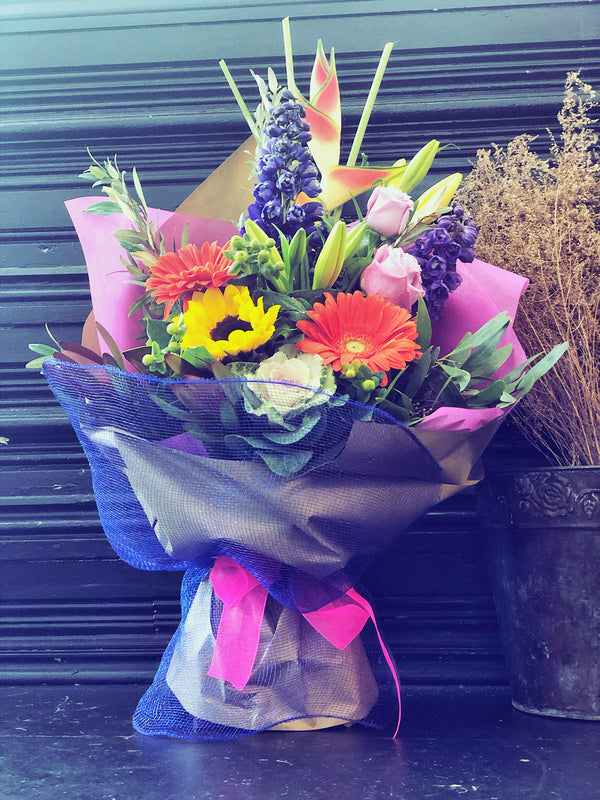 Colourful fresh flowers arrangement in container