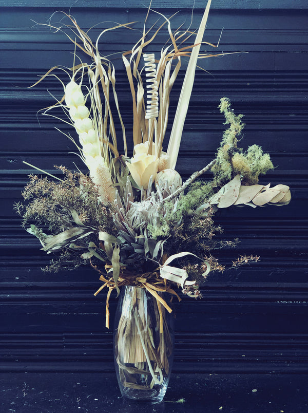 white dried flower arrangement in glass vase